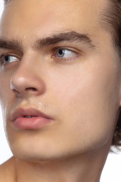 Close-up face of young handsome man isolated on white studio background. Concept of mens health, beauty, self-care, body and skin care. — стоковое фото