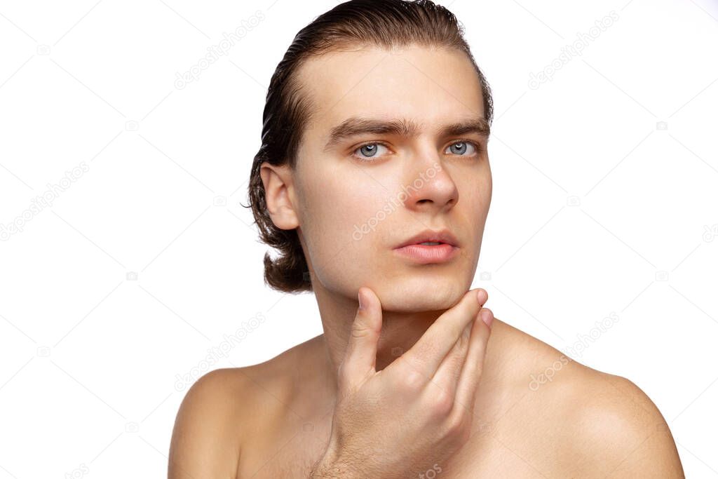 Close-up portrait of young handsome man isolated on white studio background. Concept of mens health, beauty, self-care, body and skin care.