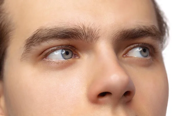 Closeup male blue eyes of young handsome man isolated on white studio background. Concept of mens health, vision, self-care, medicine and cosmetics. — Stock Photo, Image