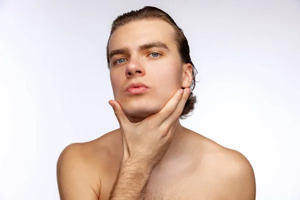 Close-up portrait of young handsome man isolated on white studio background. Concept of mens health, beauty, self-care, body and skin care. — стоковое фото