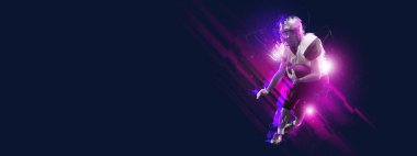 Amerikan futbolcusunun hareketli olduğu parlak bir poster ve karanlık arka planda çokgen ve akışkan neon elementlerle izole edilmiş top ile eylem. Sanat, yaratıcılık, spor