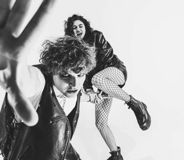 Monochrome portrait of crazy musicians, young couple wearing black leather outfits gesturing, moving on white studio background. Music, youth — Foto Stock