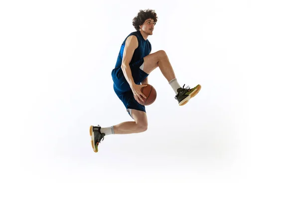 Retrato dinâmico de homem jovem, jogador de basquete jogando basquete isolado em fundo branco. Conceito de esporte, movimento, energia e ação — Fotografia de Stock