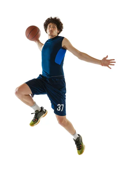 Giovane giocatore di basket muscolare in azione, movimento isolato su sfondo bianco. Concetto di sport, movimento, energia e stile di vita dinamico e sano. — Foto Stock