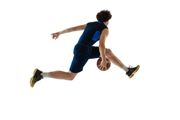 Retrato dinâmico de homem jovem, jogador de basquete jogando basquete isolado em fundo branco. Conceito de esporte, movimento, energia e ação — Fotografia de Stock