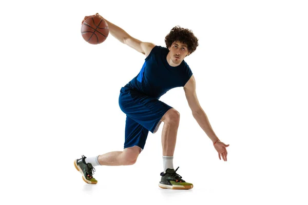 Jovem jogador de basquete muscular em ação, movimento isolado em fundo branco. Conceito de esporte, movimento, energia e estilo de vida dinâmico e saudável. — Fotografia de Stock