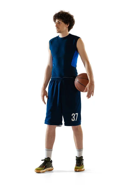 Full-length portrait of young muscular basketball player posing isolated on white background. Concept of sport, movement, energy and dynamic, healthy lifestyle. — Stok Foto