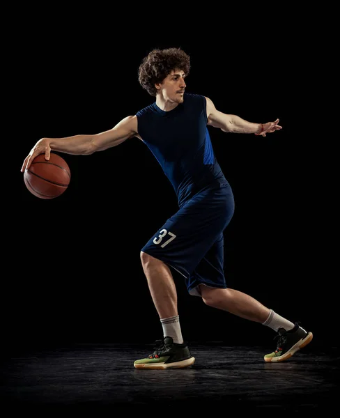 Professional basketball player in action and motion isolated on dark background. Concept of sport, competition, achievements, game. — 스톡 사진