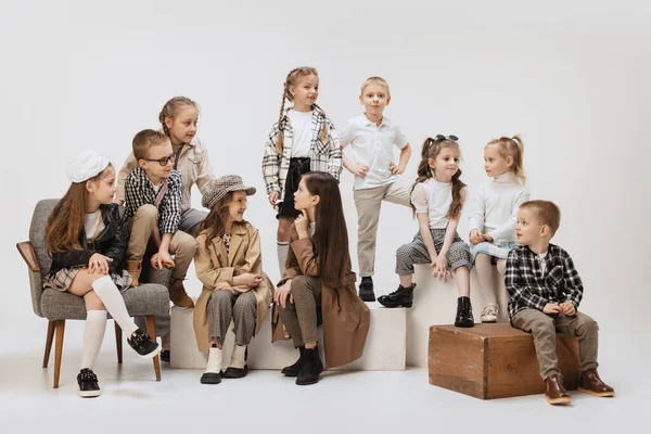 Група красивих дітей, маленькі дівчатка і хлопчики в сучасному вбранні позують на сірому студійному фоні. Краса, дитяча мода, освіта, концепція щасливого дитинства . — стокове фото
