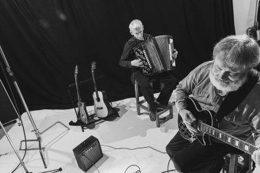 İki son sınıf öğrencisi, elektro gitar ve akordeon çalan müzisyenler. Müzik stüdyosunda retro müzik grubunun tekrarı. Sanat, müzik, tarz ve yaratılış kavramı. Tek Renkli