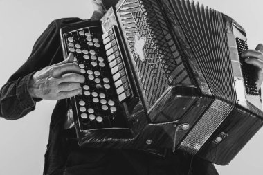 Monochrome portrait of seniot man, retro musician playing the accordion isolated on white background. Concept of art, music, style, older generation, vintage