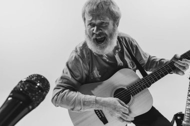 Duygusal kıdemli sakallı adam, beyaz arka planda gitar çalan müzisyen. Prova üssü. Sanat kavramı, müzik, tarz, eski nesil, bağbozumu