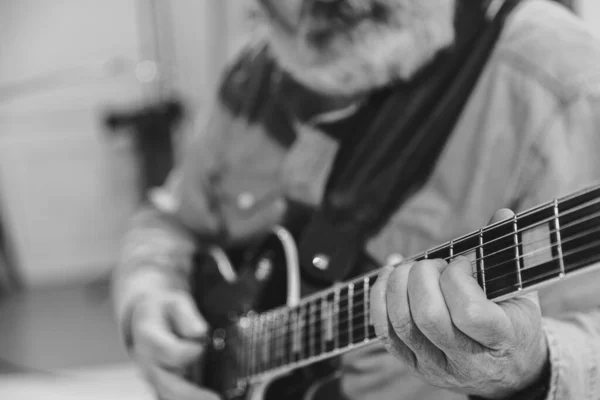 Close-up hands and electric guitar. Cropped monochrome portrait of man, rock musician playing guitar isolated on light background. Concept of music, style, art — 스톡 사진