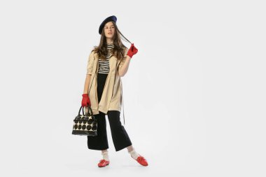 Moda fotoğrafı. Güzel bir genç kızın portresi, geçmişe dönük giysiler içinde beyaz stüdyo arka planında poz veriyor. Sanat anlayışı, nezaket, gençlik, bağbozumu