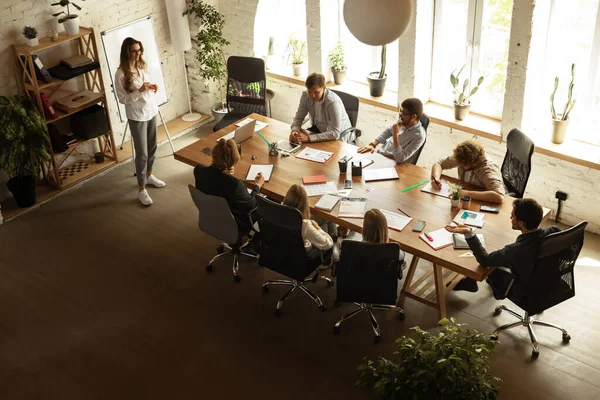 Top view of group of young people, co-workers during working process, meeting at office, indoors. Work, finance, tech and business concept. Loft style — Foto de Stock