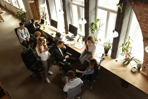 Young people talking, working with colleagues, co-workers at loft style office. Business, urban lifestyle, work, finance, tech concept. Aerial view – stockfoto