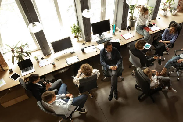 Working process at modern business company. Young men and women discussing something with coworkers, sitting at office table. Concept of team, job, career — Photo