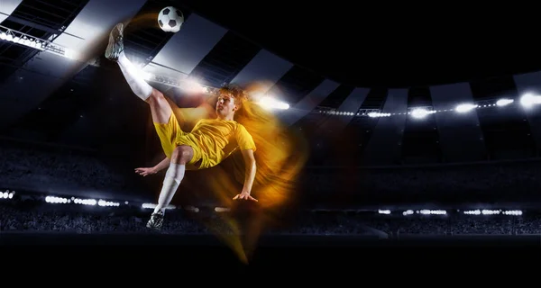 Futebol profissional ou jogador de futebol em ação no estádio com lanternas, chutando bola para ganhar gol. Conceito de esporte, competição, movimento, superação. — Fotografia de Stock