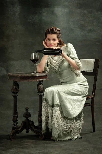 Εννοιολογικό πορτρέτο του νεαρού γοητευτικού κοριτσιού κατ 'εικόνα του μεσαιωνικού βασιλικού προσώπου ή της υποκόμισσας που ποζάρει απομονωμένη σε σκοτεινό φόντο. Σύγκριση της έννοιας των εποχών. Σύγχρονη τέχνη, ομορφιά — Φωτογραφία Αρχείου