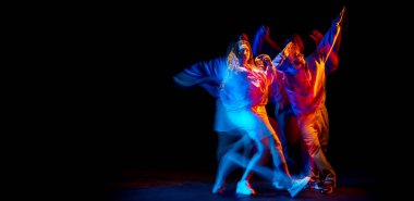 Dans gösterisi. Esnek erkek ve kız, hareket halindeki hip-hop dansçıları ve mavi ışıklı dans salonunun karanlık arka planında izole edilmiş aksiyon. Gençlik kültürü, hip-hop, hareket