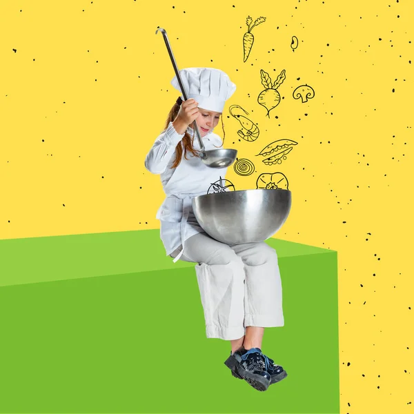 한 여자 아이는 흰 요리용 유니폼을 입고 요리 모자를 쓰고 노란색 배경에 고립된 커다란 상자 위에 앉아 있습니다. — 스톡 사진