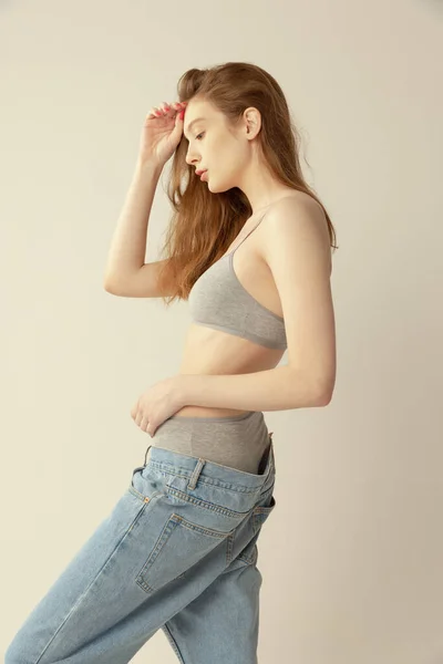 Smal Ung Rödhårig Flicka Poserar Grå Underkläder Och Överdimensionerade Jeans — Stockfoto