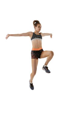 Uzun atlama tekniği. Spor üniformalı, beyaz arka planda atlayan profesyonel bayan sporcunun stüdyo fotoğrafı. Spor, eylem, hareket, hız, sağlıklı yaşam tarzı kavramı. İlan için alanı kopyala