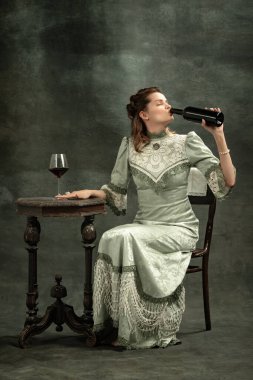 Kırmızı şarabı tatmak. Ortaçağ kraliyet mensubu ya da koyu arkaplanda şarap içen Vikontes 'in tasviri olan çekici genç bir kızın kavramsal portresi. Dönem konsepti, moda, sanat, reklam karşılaştırması.