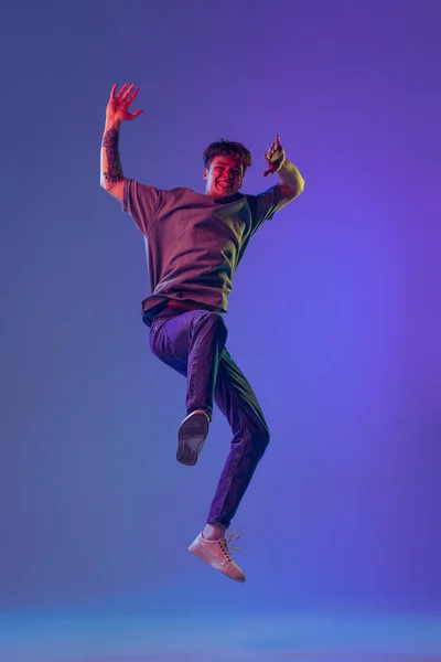 Springen Jonge Roodharige Man Student Geïsoleerd Blauwe Studio Achtergrond Neon — Stockfoto