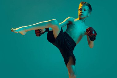 - Yakın çekim. Genç sporcular, anne sporunun acemi dövüşçüsü Cyan renk arka planında izole edilmiş. Ana dövüşçüsü, hareket, spor, meydan okumalar. İlan için alanı kopyala