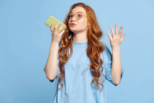 Emocionální Mladá Zrzka Dívka Student Pomocí Telefonu Izolované Pozadí Modrého — Stock fotografie