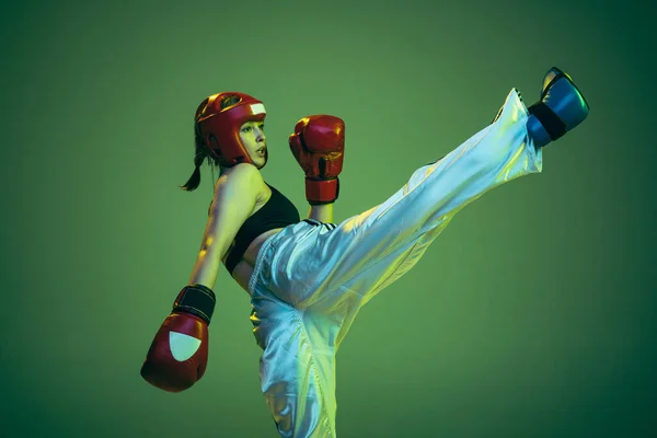 灵活的女拳击手 戴着拳击手套和头盔 在霓虹灯下练习隔离在绿色工作室背景下 成功的概念 成就和挑战 — 图库照片