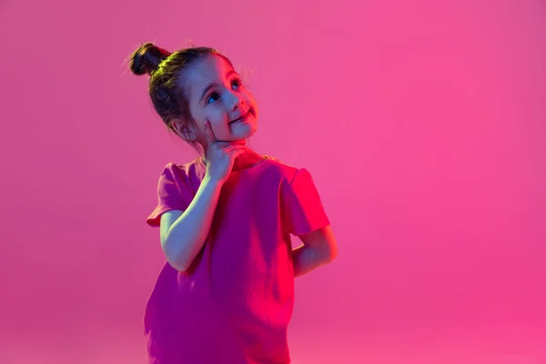 夢を見てる かわいい女の子の肖像画 ピンクのTシャツを着ている子供は マゼンタの色の背景に孤立ポーズ 子供の感情 ファッション 美しさ 学校や広告の概念の概念 — ストック写真