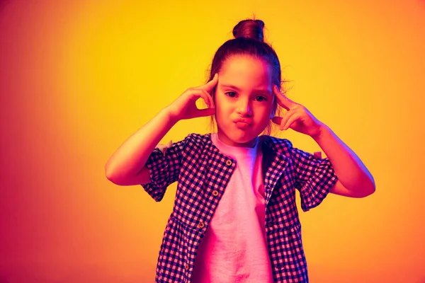 問題だ頭痛がする 感情的にかわいい女の子は 子供ネオンで黄色の赤い色の背景に孤立ポーズ 子供の感情 ファッション 美しさ 学校や広告の概念の概念 — ストック写真
