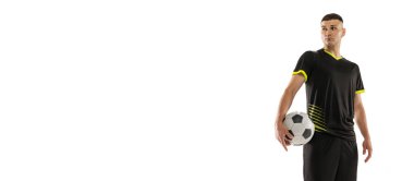 Siyah futbol takımındaki profesyonel erkek futbolcunun beyaz stüdyo arka planında top ile poz verdiği broşür. Spor anlayışı, hedefler, rekabet, erkek hobisi, meslekler