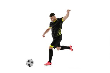 Hareket halindeki profesyonel erkek futbol oyuncusu ve beyaz stüdyo arka planında izole edilmiş aksiyon. Spor anlayışı, hedefler, rekabet, hobi, reklam, dünya kupası. Siyah futbol takımı giyen sporcular
