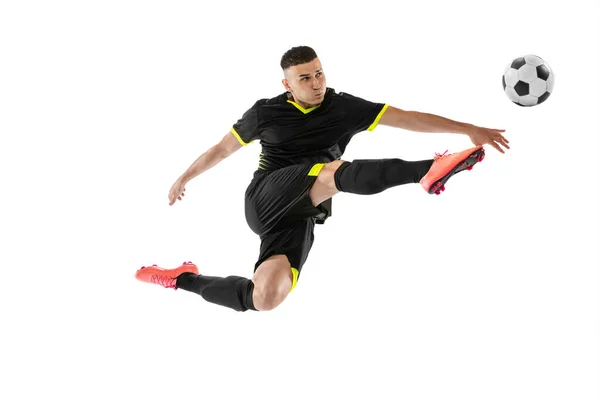 跳高在白人工作室背景下孤立的职业足球运动员训练动态肖像 体育的概念 身穿黑衣足球的运动员 — 图库照片