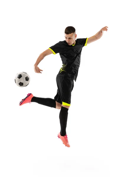 白いスタジオの背景に隔離されたプロの男性サッカー選手のトレーニングのダイナミックな肖像画 スポーツ ワールドカップの概念 黒サッカーを着たスポーツマン — ストック写真