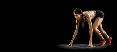 Başlamaya hazırlanıyorum. Siyah arka planda yalnız koşan ciddi ve sportif bir kadın. Spor, atletizm, rekabet ve aktif yaşam tarzı konsepti. İlan, metin için boşluk kopyala