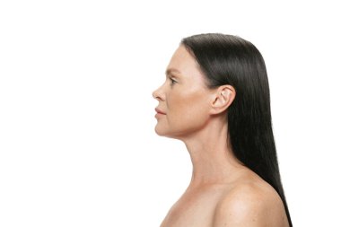 Orta yaşlı, bakımlı ve beyaz arka planda uzun siyah saçlı güzel bir kadın profili. Kozmetik, spa, yaşla ilgili değişiklikler, yüz gerdirme ve cilt bakımı konsepti. İlan için alanı kopyala