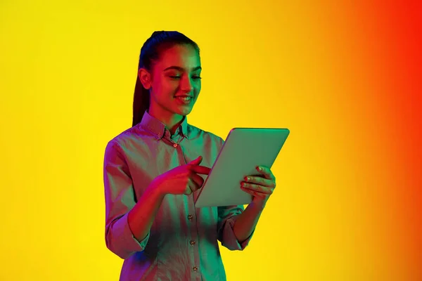 Tablet Kullanan Genç Bir Kızın Portresi Neon Işıklarıyla Izole Edilmiş — Stok fotoğraf