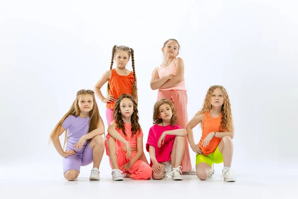 現代の振付のレッスン 白のスタジオの背景に隔離された明るいカラフルな服のダンスの幸せな アクティブな小さな女の子のダンスグループ ファッション アート 子供時代 趣味の概念 — ストック写真
