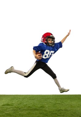 Hareket halinde. Atletik çocuk, beyaz arka planda izole edilmiş spor üniformalı Amerikan futbolcusu ve kask eğitimi. Spor kavramı, zorluklar, eylem, başarılar.