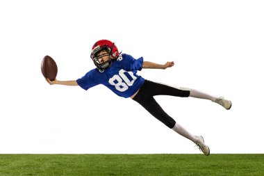 Küçük çocuğun dinamik portresi, Amerikan futbol eğitiminin acemi oyuncusu yeşil çimen döşemeli beyaz arka planda izole edilmiş. Spor anlayışı, hareket, başarılar. İlan için alanı kopyala