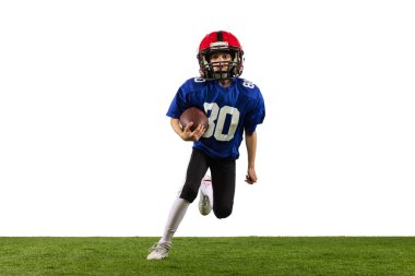 Küçük çocuğun dinamik portresi, Amerikan futbol eğitiminin acemi oyuncusu yeşil çimen döşemeli beyaz arka planda izole edilmiş. Spor anlayışı, hareket, başarılar. İlan için alanı kopyala