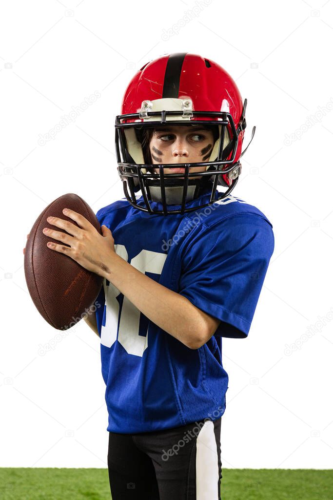 Future champion. Athletic kid, beginner american football player in sports uniform and helmet training isolated on white background. Concept of sport, challenges, action, achievements.