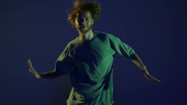 挥挥手一个快乐的年轻人 嘻哈舞者 在霓虹灯下在深蓝色背景下独自跳舞 现代舞蹈艺术 时尚观念 — 图库视频影像