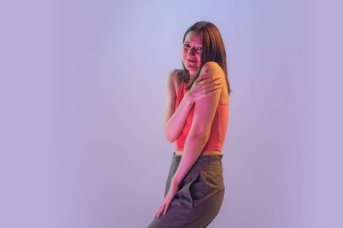 Korkudan. Kadın hakları için. Mavi arka planda izole edilmiş korkmuş genç bir kız. İnsan duyguları kavramı, yüz ifadesi, gençlik, arzu, satış.