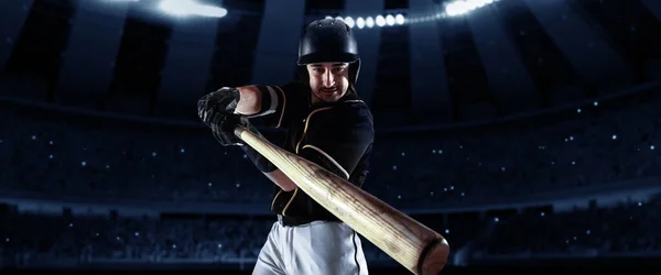 Powerful hit. Front camera view of of professional baseball player with baseball bat in action during match in crowed sport stadium at evening time. Sport, win, winner, competition concepts.