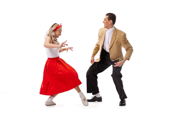 Expressive couple of dancers in vintage retro style outfits dancing social dance isolated on white background. Timeless traditions, 60s ,70s american fashion style. Dancers look excited